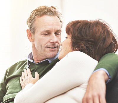 Buy stock photo A mature couple relaxing at home. A happy senior man and woman in love sharing a romantic moment on the couch