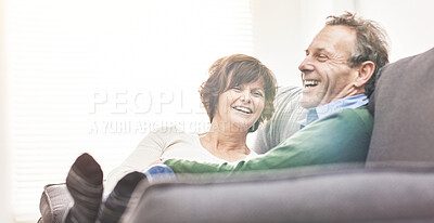 Buy stock photo A mature couple relaxing at home. A happy senior man and woman in love sharing a romantic moment on the couch