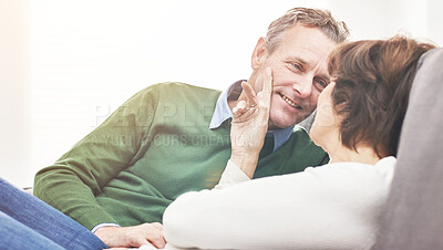 Buy stock photo A mature couple relaxing at home. A happy senior man and woman in love sharing a romantic moment on the couch
