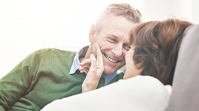 Buy stock photo A mature couple relaxing at home. A happy senior man and woman in love sharing a romantic moment on the couch