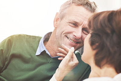 Buy stock photo A mature couple relaxing at home. A happy senior man and woman in love sharing a romantic moment on the couch