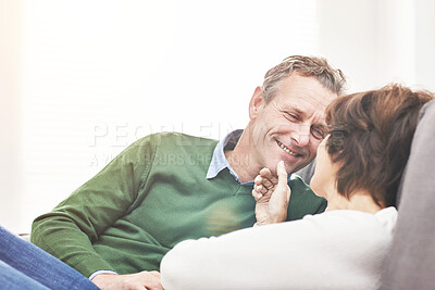 Buy stock photo A mature couple relaxing at home. A happy senior man and woman in love sharing a romantic moment on the couch