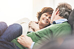 A mature couple relaxing at home. A happy senior man and woman in love sharing a romantic moment on the couch