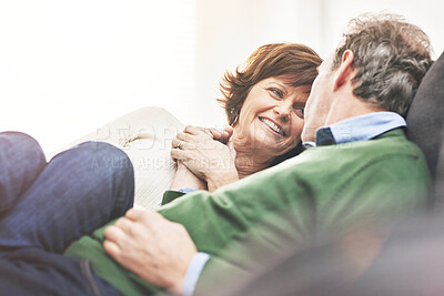 Buy stock photo A mature couple relaxing at home. A happy senior man and woman in love sharing a romantic moment on the couch