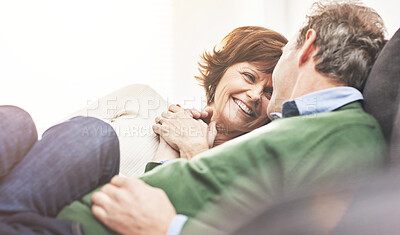 Buy stock photo A mature couple relaxing at home. A happy senior man and woman in love sharing a romantic moment on the couch