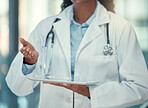 Hand of a doctor holding a digital tablet in the hospital. Closeup on hand of a doctor making a gesture while using a wireless device. Medical professional browsing an online app on a digital tablet