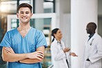 Portrait of a male nurse with his team in the background in the hospital. Happy, smiling and confident nurse with doctors in medicine, health and medical care. Medical team, healthcare and nursing