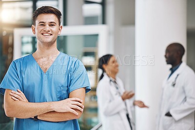Buy stock photo Portrait of a male nurse with his team in the background in the hospital. Happy, smiling and confident nurse with doctors in medicine, health and medical care. Medical team, healthcare and nursing