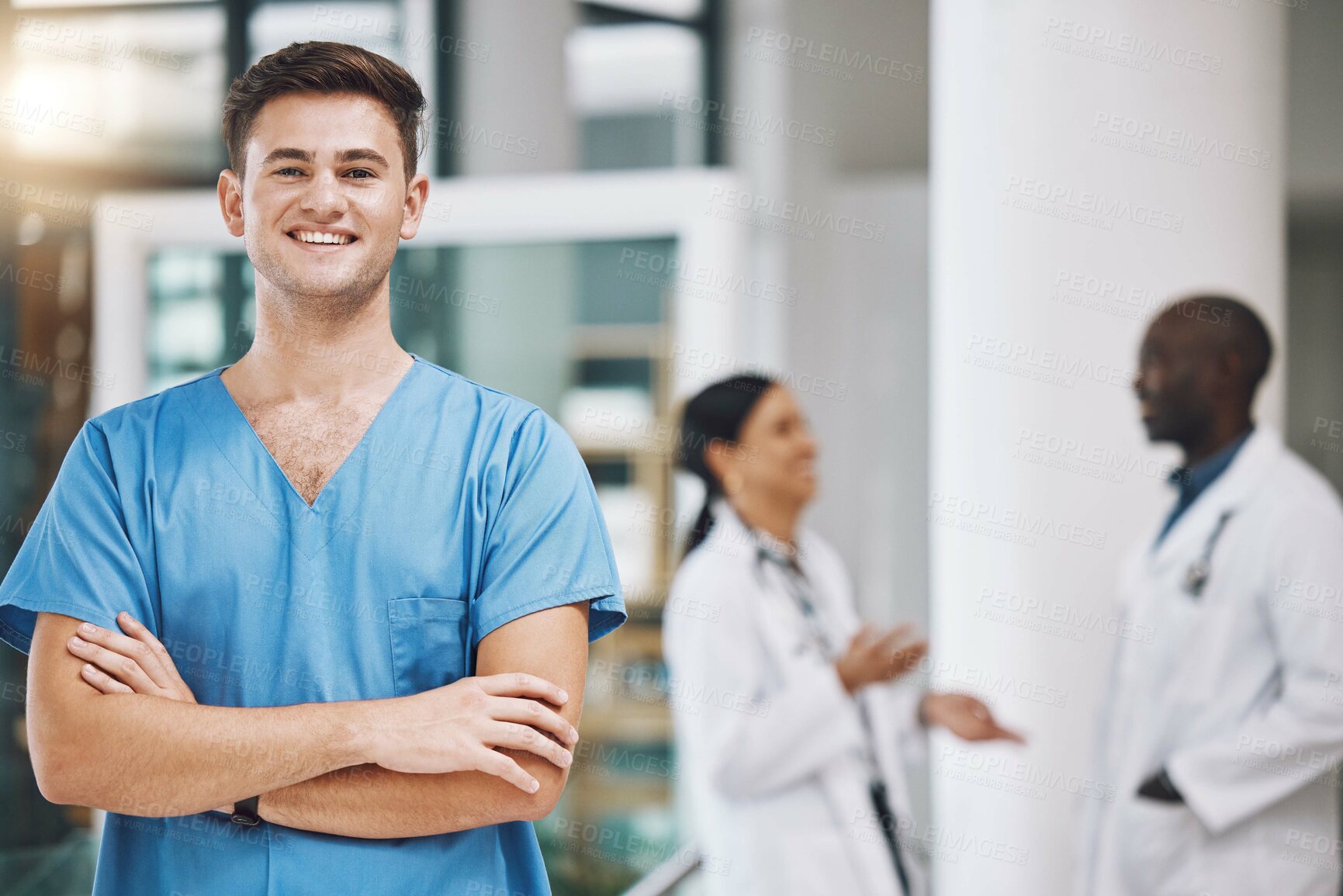 Buy stock photo Portrait of a male nurse with his team in the background in the hospital. Happy, smiling and confident nurse with doctors in medicine, health and medical care. Medical team, healthcare and nursing