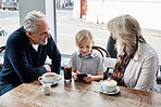Family, kid and cafe with phone, video or click with smile for soda, relax or streaming on app. Grandparents, family and child with tea cup, coffee shop and smartphone with reading, press and cartoon
