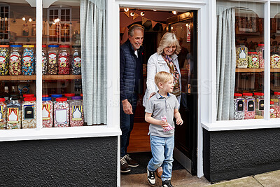 Buy stock photo Man, woman and child on street by candy shop for product, shopping and choice for love, care or bonding. Grandparents, boy kid and retail store with walk for sweets, sidewalk or dessert with family