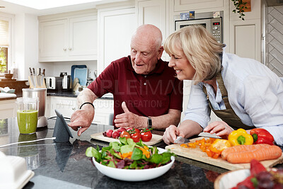 Buy stock photo Home, cooking and senior couple with a tablet, online recipe and digital app with instructions, vegetables or social media. Kitchen, elderly man or old woman with technology, internet or healthy food