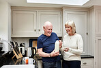 Senior, couple and milk in kitchen with smile for coffee, break or beverage in the morning at home. Elderly, man and woman with tea mugs for breakfast, happiness and bonding in house or apartment
