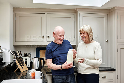 Buy stock photo Senior, couple and milk in kitchen with smile for coffee, break or beverage in the morning at home. Elderly, man and woman with tea mugs for breakfast, happiness and bonding in house or apartment