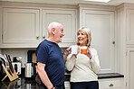 Coffee, funny and senior couple in kitchen at home together in the morning for conversation, love and healthy connection. Tea, laughing and elderly man and woman with hot drink in mug in retirement