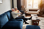 Laptop, smile and retirement with a senior couple on a sofa in their home living room for entertainment. Computer, pointing or gesture with a happy elderly man and woman streaming in an apartment