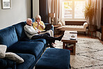 Laptop, relax and retirement with a senior couple on a sofa in the living room of their home for entertainment. Computer, video or happy with an elderly man and woman streaming in their apartment