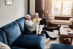 Relax, senior couple and technology on the sofa for a movie, film or comedy show online. Happy, talking and an elderly man and woman with a computer and phone on the home couch for the internet