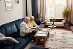 Senior couple, documents and planning budget on sofa for investment, assets and bills at home. Man, woman and check paperwork for insurance information, mortgage loan and admin of retirement savings 