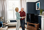Happy, dance and senior couple on a living room with music, love and bonding in their home. Retirement, celebration and old people in a lounge with radio, podcast or fun with care, trust or support