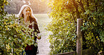 Countryside, morning and woman in nature walking for wellness, fresh air and relax outdoors. Trees, fence and person in field, meadow and farm for calm, peace and freedom in natural environment