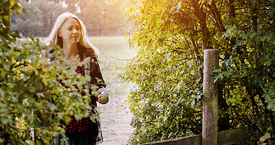 Buy stock photo Countryside, morning and woman in nature walking for wellness, fresh air and relax outdoors. Trees, fence and person in field, meadow and farm for calm, peace and freedom in natural environment