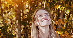 Fall, nature and face of happy woman with freedom and relax outdoor in garden or backyard. Autumn, trees and leaves in forest with person in park on vacation or holiday with sunshine in morning