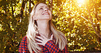 Outdoor, thinking and woman with a smile, sunshine and summer break with happiness, relax and cheerful. Outside, forest and woods with girl, lens flare and model with wellness, environment and ideas