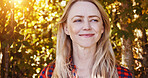 Sunshine, happy and face of woman by trees for wellness, fresh air and relax outdoors. Countryside, smile and person in forest, woods and nature for morning, joy and freedom in natural environment