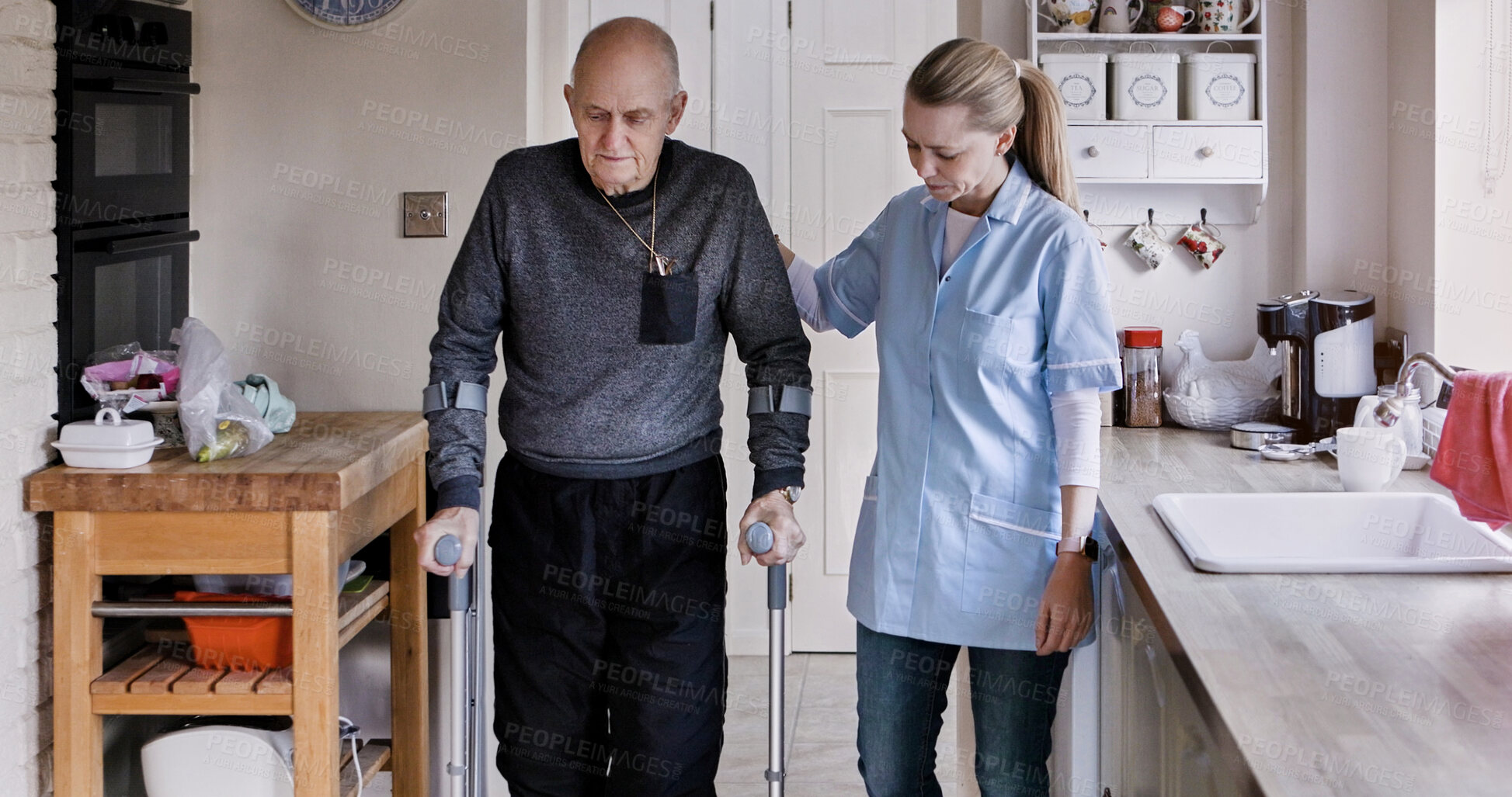 Buy stock photo Nurse help elderly man in crutches in home kitchen, medical rehabilitation and recovery. Caregiver, person with a disability walk and support, health or physiotherapy, healing injury or accident pain