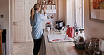 Spring cleaning, kitchen and woman cleaner doing house work in a home for hygiene. Housekeeper, organize and packing dishes for chores and maintenance with care and wellness with maid working