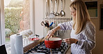 Woman, cooking and stir pot in kitchen, home and smile for healthy ingredients, meal prep and nutrition. Chef person, stove and food with idea, thinking and process for diet, lunch or dinner in house