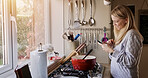 Woman, phone and smile for cooking in kitchen with reading, search or video for recipe in home. Person, smartphone and happy with social media, blog or info for diet, nutrition or wellness in house
