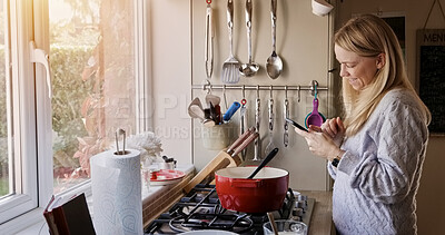 Buy stock photo Woman, phone and smile for cooking in kitchen with reading, search or video for recipe in home. Person, smartphone and happy with social media, blog or info for diet, nutrition or wellness in house
