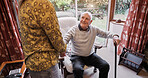 Old man, talking and relax in home with caregiver in retirement with walking stick and support. Senior, person and conversation with woman in apartment, living room and house with care and discussion