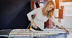 Woman, housewife and ironing of garment in living room for housekeeping, cleaning or washing. Female person, working or domestic chore by iron, appliance and electricity for, neat, fresh and clothes
