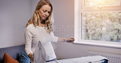 Buy stock photo Woman iron fabric on board in house, laundry and housework chores in living room, apartment or home Housekeeping service, electrical appliance and clothes, maid cleaning and domestic work for hygiene