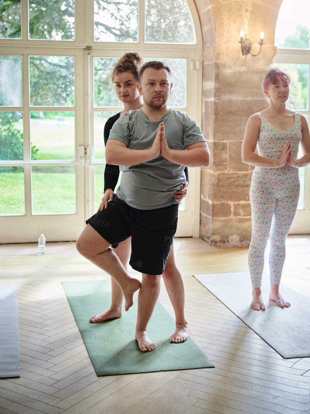 Buy stock photo Man, yoga and personal trainer in class for exercise, workout or posture in namaste pose on mat at gym or dojo. Coach or relax helping yogi for balance, mindfulness or support in pilates or wellness