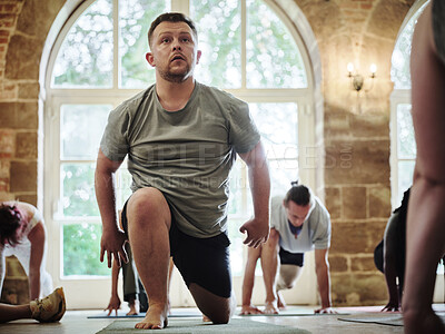 Buy stock photo Yoga, class and man in gym to exercise, fitness and healthy body for holistic wellness. Serious person, club and practice pilates with group of people stretching, kneeling on floor and thinking