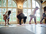 People, yoga and class in exercise, workout or stretching for health and wellness together at gym or dojo. Yogi group in warm up, body stretch or balance for fitness, pilates or indoor lesson session