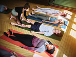 Yoga, personal trainer with class stretching for fitness, exercise and wellness in studio. Health club, pilates and instructor with group of people for flexibility workout, balance and training