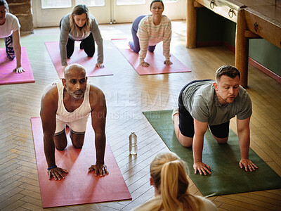Buy stock photo Yoga class, fitness and people stretching on floor for exercise, workout wellness and personal trainer or mentor. Group of men and women in cat cow or floor pose for pilates, training and support
