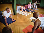 Instructor, group or people learning in yoga class for meditation or body flexibility in zen studio. Man, start or calm women in pilates stretching for balance, energy or wellness to relax together