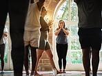 Praying, instructor teaching or women in yoga class for meditation or mindfulness in zen studio. Coach, support or calm people in pilates club for chakra energy, aura or wellness to relax together