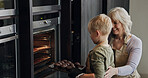 Grandmother, child and baking cupcakes at oven in kitchen, care and learning together in home. Happy grandma, boy and kid cooking muffins, love and family bonding, smile or prepare fresh dessert food