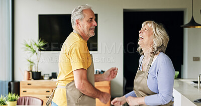 Buy stock photo Senior, couple and dancing in living room or happy with bonding, retirement and marriage in apartment. Elderly, man or woman with energy for laughing, apron and romance with smile in house or home