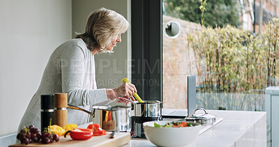 Buy stock photo Laptop, cooking and senior woman in the kitchen of modern home for healthy or diet supper. Food, technology and elderly female person preparing a meal for dinner or lunch with computer at house.