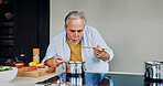 Cooking, home and senior man taste food for lunch, supper and prepare healthy dinner in kitchen. Retirement, wellness and mature person with natural ingredients, cutting vegetables and organic meal