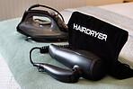 Hairdryer, hotel room and equipment tool for beauty style at accommodation for hospitality service, furniture or lodge. Iron, bedroom and convenience in London for resort weekend, holiday or vacation