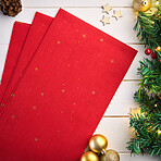 Christmas, wrapping paper and decorations on table for gift, present or offering at holiday celebration. Ornament, holly and trinket with fancy covering for surprise, handout or donation from above